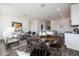 Open concept living and dining area with a view of the kitchen, featuring wood floors and ample natural light at 18052 W Sand Hills Rd, Surprise, AZ 85387