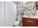 Nicely updated bathroom showcasing modern fixtures, patterned wallpaper, and a shower with a white curtain at 19202 N 14Th St, Phoenix, AZ 85024