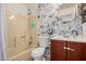 Nicely updated bathroom showcasing modern fixtures, patterned wallpaper, and a shower/tub combination at 19202 N 14Th St, Phoenix, AZ 85024