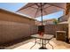 Cozy backyard featuring a patio table with an umbrella, rock landscaping, and block wall at 1968 E Emily Ln, Gilbert, AZ 85295
