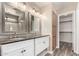Bathroom features a double sink vanity, granite countertops, updated fixtures and lighting, plus a walk-in closet for extra storage at 1968 E Emily Ln, Gilbert, AZ 85295