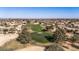 Scenic aerial shot of a lush green golf course surrounded by desert homes under a clear blue sky at 19714 N Rim Dr, Surprise, AZ 85374