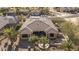An inviting, desert home featuring a well-manicured yard with mature palms and a cozy outdoor living space at 19714 N Rim Dr, Surprise, AZ 85374