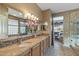 Bathroom with double sinks, granite counters, and shower view at 19714 N Rim Dr, Surprise, AZ 85374