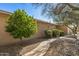 Home exterior with a stone walkway, desert landscaping, and lush greenery, creating a serene outdoor space at 19714 N Rim Dr, Surprise, AZ 85374
