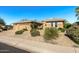 Well-manicured desert landscaping complements this charming single-story home, with a wide sidewalk at 19714 N Rim Dr, Surprise, AZ 85374