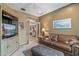Cozy living room featuring a brown leather sofa, TV console, and neutral-toned walls at 19714 N Rim Dr, Surprise, AZ 85374
