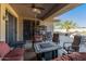 Cozy covered patio with a ceiling fan and comfortable seating around a stone-topped fire pit at 19714 N Rim Dr, Surprise, AZ 85374