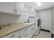 Convenient laundry room with granite countertops, washer, dryer, and storage cabinets at 20121 N 76Th St # 1019, Scottsdale, AZ 85255