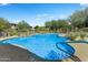 Beautiful community pool with desert landscaping, rock features, and blue skies at 20121 N 76Th St # 1019, Scottsdale, AZ 85255