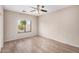 Bright bedroom featuring a ceiling fan, and wood floors, with a window overlooking the yard at 2024 E Dust Devil Dr, San Tan Valley, AZ 85143