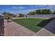 Low-maintenance backyard featuring artificial grass, desert landscaping, and a block fence for privacy at 20638 N 11Th St, Phoenix, AZ 85024