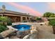 Beautiful backyard with a rock-rimmed pool, covered patio, and cozy seating, perfect for relaxation and entertaining at 22231 N 55Th St, Phoenix, AZ 85054