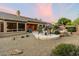 Spacious backyard with a covered patio, seating area, and beautiful desert landscaping, perfect for outdoor living at 22231 N 55Th St, Phoenix, AZ 85054
