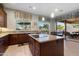 Stylish kitchen with stone countertops, custom cabinetry, an island cooktop, and an open view to the backyard at 22231 N 55Th St, Phoenix, AZ 85054