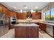 Gourmet kitchen with custom cabinets, stainless appliances, center island, tile backsplash and pendant lighting at 22231 N 55Th St, Phoenix, AZ 85054
