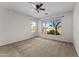 A bedroom with carpet floors, a ceiling fan, and two windows with views at 22815 N Arrellaga Dr, Sun City West, AZ 85375