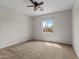 A bedroom with carpeted floors, a ceiling fan, and one window with views at 22815 N Arrellaga Dr, Sun City West, AZ 85375