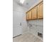 Functional laundry room with ample cabinet space and tile flooring for easy cleaning at 22815 N Arrellaga Dr, Sun City West, AZ 85375