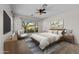 A staged main bedroom features carpeted floors, a ceiling fan, and a large window at 22815 N Arrellaga Dr, Sun City West, AZ 85375