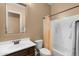 Well-lit bathroom with a vanity sink, toilet, and shower with a peach-colored shower curtain at 2304 N Steele Cir, Mesa, AZ 85207