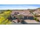 Stunning view of a luxurious home featuring a three car garage, beautiful tile roof, and colorful landscaping at 2304 N Steele Cir, Mesa, AZ 85207