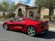 Stunning red sports car parked in front of a luxury home with arched doorways and manicured landscaping at 2304 N Steele Cir, Mesa, AZ 85207