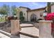 Inviting brick path leading to the arched doorway, flanked by decorative stone columns and lush desert landscaping at 2304 N Steele Cir, Mesa, AZ 85207