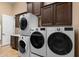 Spacious laundry room featuring stacked washer/dryer units, extensive cabinetry, and ample counter space at 2304 N Steele Cir, Mesa, AZ 85207