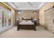 Bright bedroom featuring a wood accent wall, fan, and access to the backyard at 2304 N Steele Cir, Mesa, AZ 85207