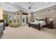 Spacious main bedroom featuring a wood accent wall, ceiling fan, and access to the backyard at 2304 N Steele Cir, Mesa, AZ 85207