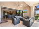 Covered outdoor living space featuring comfortable seating, multiple TVs, and views of the backyard at 2304 N Steele Cir, Mesa, AZ 85207
