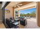 Inviting outdoor patio with comfortable seating, TV, and a view of the pool and landscaped backyard at 2304 N Steele Cir, Mesa, AZ 85207