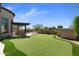 Expansive backyard putting green with lush turf, ideal for practicing your golf skills in a serene setting at 2304 N Steele Cir, Mesa, AZ 85207
