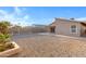 An exterior shot of the house’s backyard shows a gravel-covered lot with desert landscaping along the perimeter at 23829 N 36Th Dr, Glendale, AZ 85310