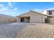 An exterior shot of the house’s backyard shows sliding glass doors leading to a gravel-covered lot at 23829 N 36Th Dr, Glendale, AZ 85310