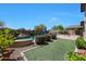 Landscaped backyard with artificial turf and a swimming pool, enhanced by lush greenery and privacy at 29706 N 127Th Ln, Peoria, AZ 85383