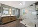 Modern bathroom featuring double vanities, and a walk-in shower with marble accents at 29706 N 127Th Ln, Peoria, AZ 85383