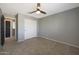 A bright bedroom with soft carpet flooring, neutral walls, and a large closet with fan at 29706 N 127Th Ln, Peoria, AZ 85383