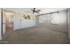 Spacious bedroom featuring a decorative white brick wall, ceiling fan, and window with sliding barn door shutters at 29706 N 127Th Ln, Peoria, AZ 85383