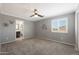 Gray bedroom featuring a window with shutters, ceiling fan, carpet, and a decorative bicycle wall hanging at 29706 N 127Th Ln, Peoria, AZ 85383
