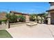 An outdoor firepit sits in a landscaped area with string lights and a pergola with bar in the backyard at 29706 N 127Th Ln, Peoria, AZ 85383