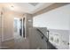Bright hallway featuring neutral walls and carpet flooring with the stairwell and multiple doorways at 29706 N 127Th Ln, Peoria, AZ 85383