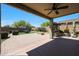 Spacious covered patio featuring a ceiling fan, outdoor kitchen, brick pavers, and a fire pit area at 29706 N 127Th Ln, Peoria, AZ 85383