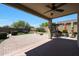 Spacious covered patio featuring a ceiling fan, outdoor kitchen, brick pavers, and a fire pit area at 29706 N 127Th Ln, Peoria, AZ 85383