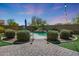 Beautiful backyard pool area featuring a rock waterfall feature and meticulous landscaping and brick paver accents at 29706 N 127Th Ln, Peoria, AZ 85383