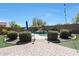Inviting swimming pool with waterfall feature surrounded by mature trees, shrubs, and manicured artificial turf at 29706 N 127Th Ln, Peoria, AZ 85383