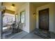 Inviting covered porch with seating, decorative door, and stylish rug creating a cozy outdoor space at 29706 N 127Th Ln, Peoria, AZ 85383