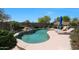 Sparkling swimming pool with rock features, surrounded by lush landscaping and a sunbathing area at 29706 N 127Th Ln, Peoria, AZ 85383