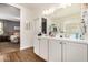 Bright bathroom features a dual sink vanity with white cabinets and views of the bedroom at 30208 W Fairmount Ave, Buckeye, AZ 85396